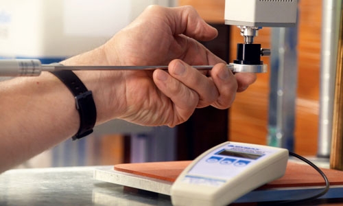 A technician uses the ACCU-CAL radiometer to test the light intensity of a UV/LED curing system.